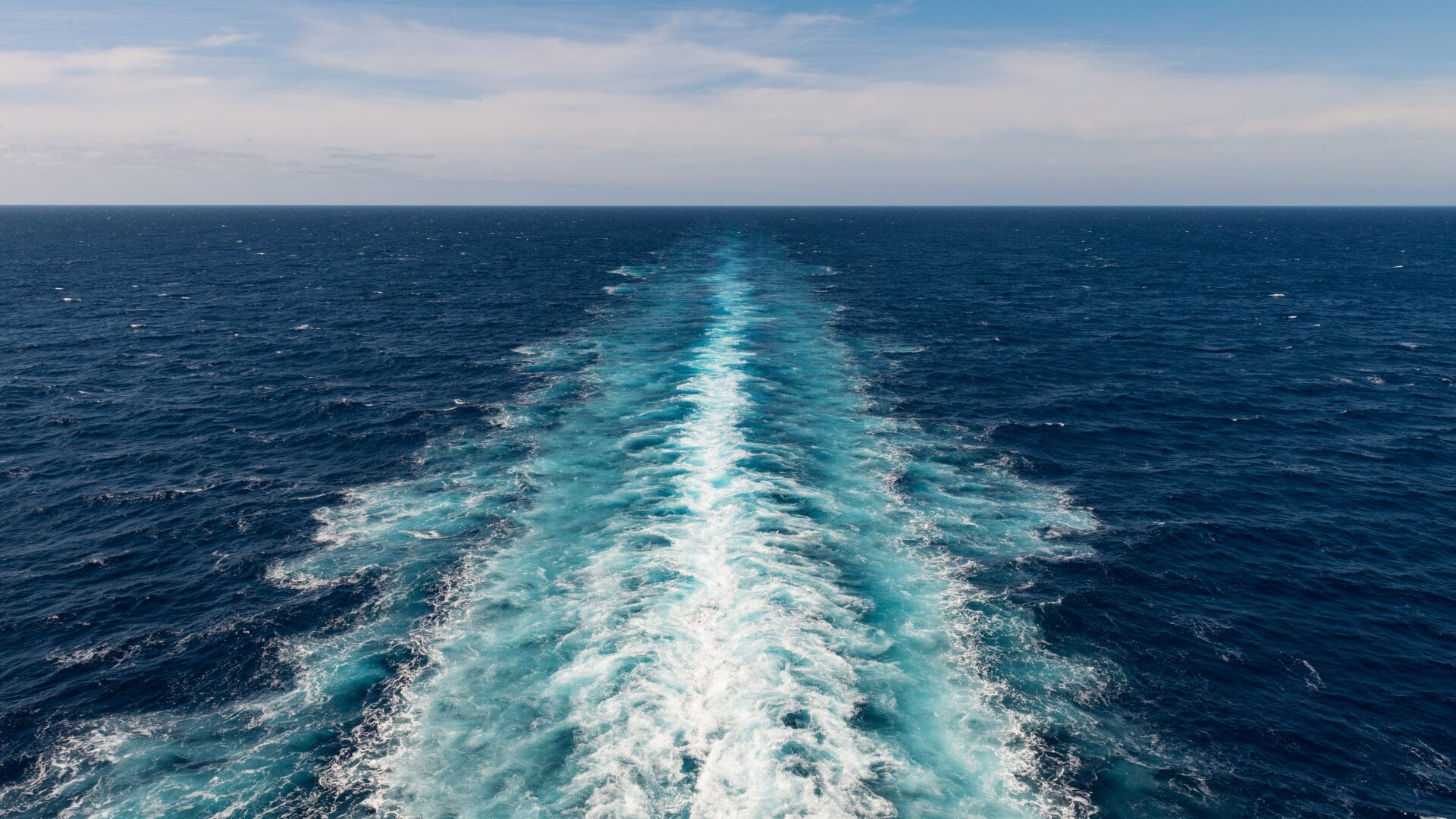 View of an ocean with a white water wake left behind, symbolizing customer churn and the ongoing challenge of retention for tech companies.
