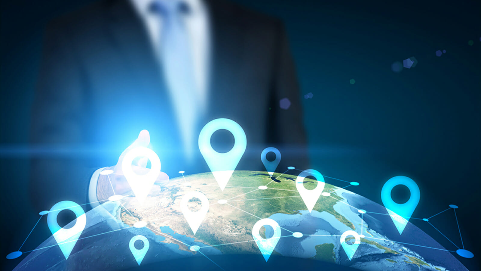 Traveling concept with businessman pointing at globe with location pin network on dark background | Phrase